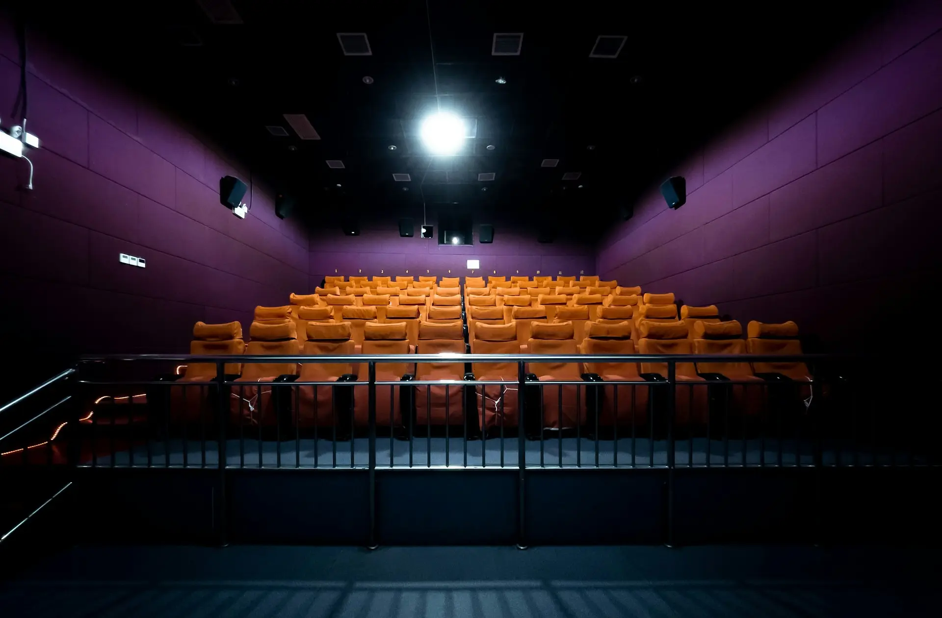 orange and white chairs with lights turned on in a stadium